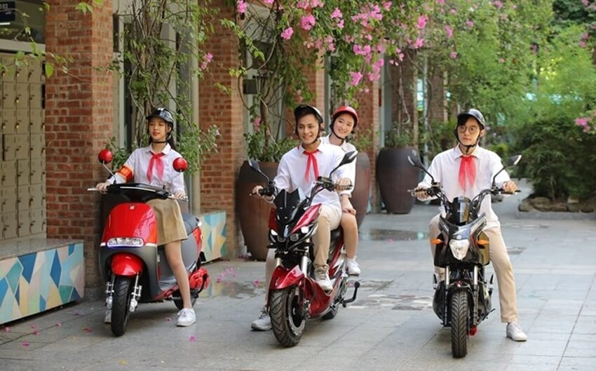 Học sinh cấp 2 đang ngồi trên xe đạp điện